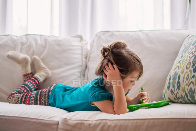 Chica jugando con la tableta digital - foto de stock