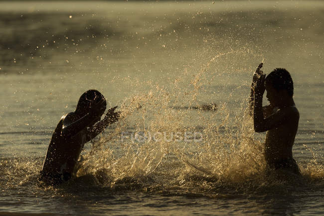 Счастливые мальчики брызгают водой — стоковое фото