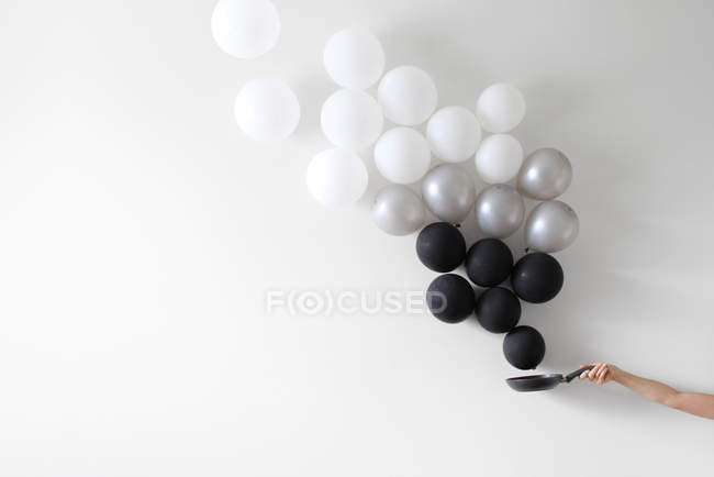 Frying pan with flying balloons — Stock Photo