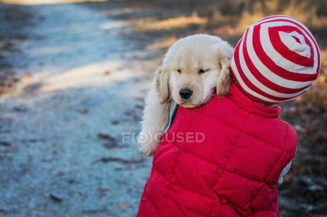 Cão carregando por menino — Fotografia de Stock