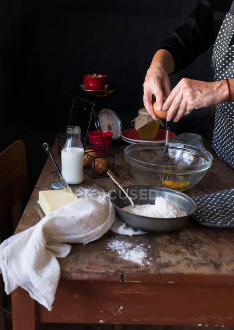 Женщина разбивает яйца в миску — стоковое фото