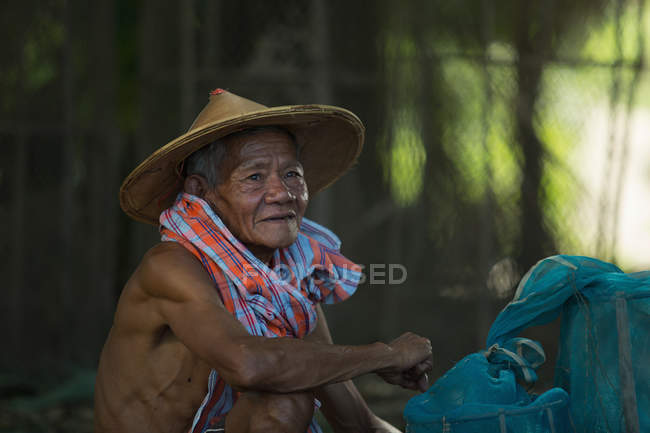 Uomo anziano seduto con pentole da pesca — Foto stock