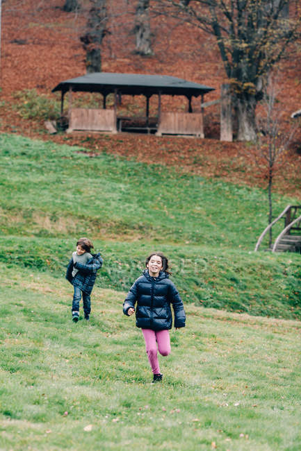Мальчик и девочка бегают в парке — стоковое фото
