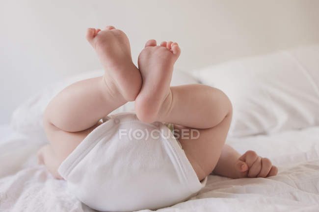 Baby boy lying down on bed — Stock Photo