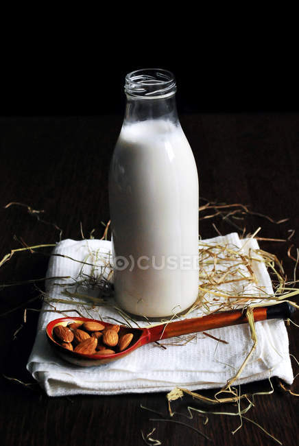 Almonds and milk in bottle — Stock Photo