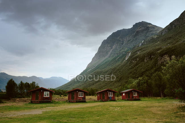 Four cottages at foot of mountain — Stock Photo