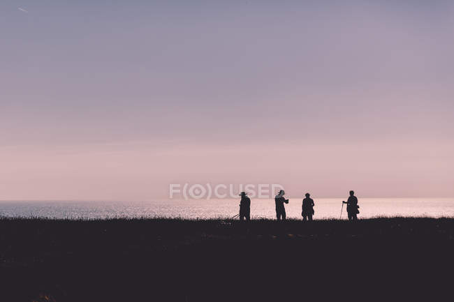 Четыре человека против моря — стоковое фото
