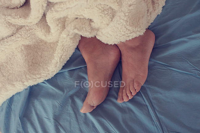Feet out from under blanket — Stock Photo