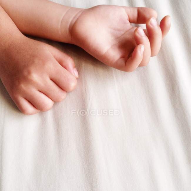 Mãos de criança na cama — Fotografia de Stock
