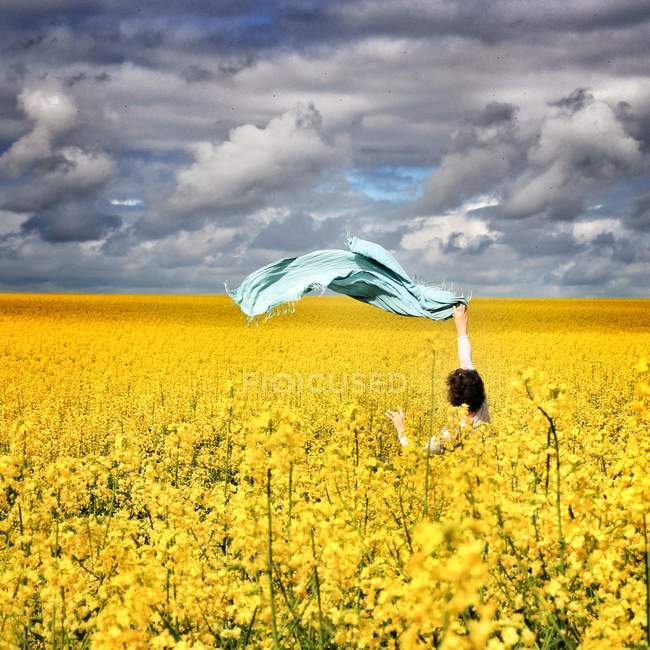 Woman standing in a rapeseed field — Stock Photo