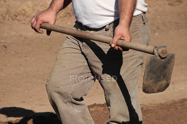 Homme tenant houe creusant — Photo de stock