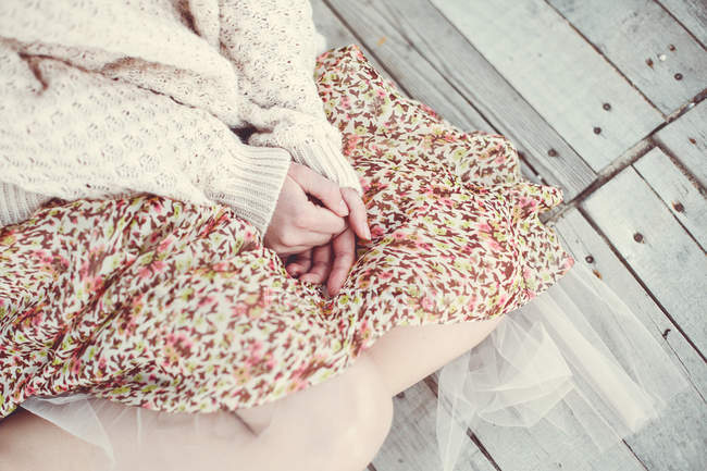 Дівчинка сидить на дерев'яні підлоги на відкритому повітрі — стокове фото