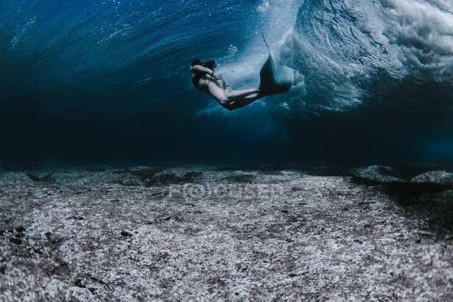 Жінка плаває під хвилями — стокове фото