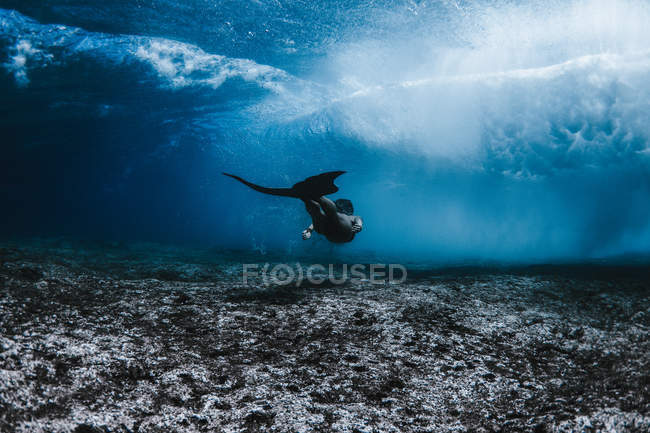 Жінка плаває під хвилями — стокове фото