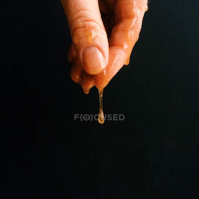 Hand tropft mit Honig — Stockfoto