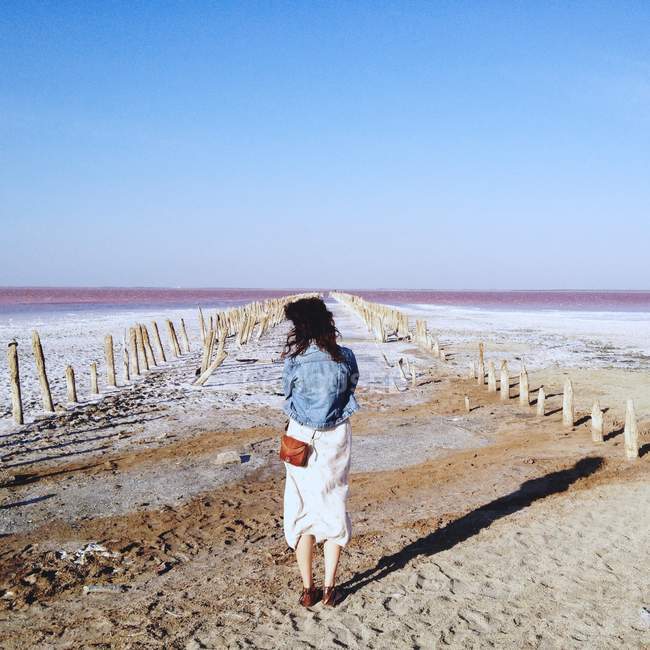Женщина стоит на песке — стоковое фото