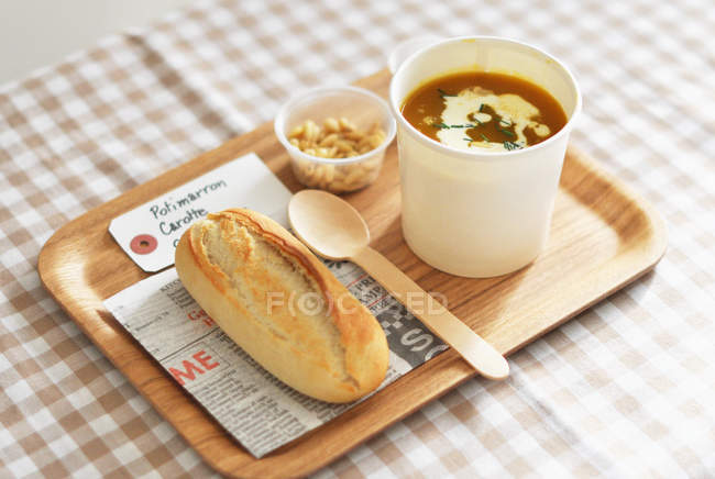 Tray with soup and bun — Stock Photo