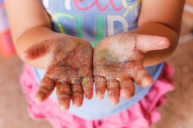 Glitter on girl hands — Stock Photo