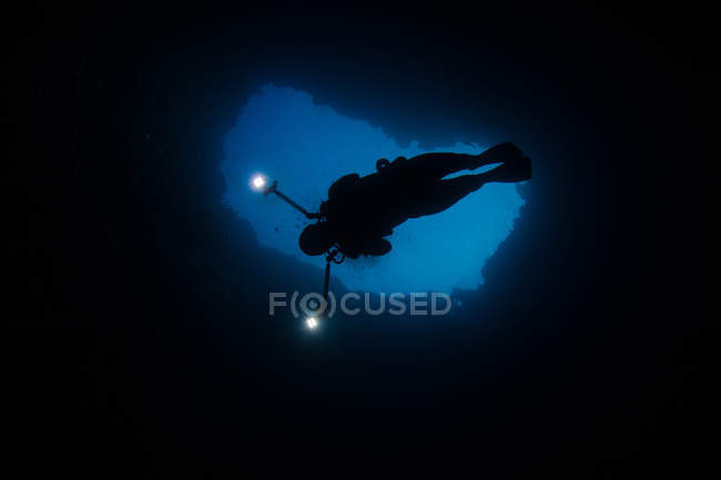 Дайвер плавает в голубой дыре — стоковое фото