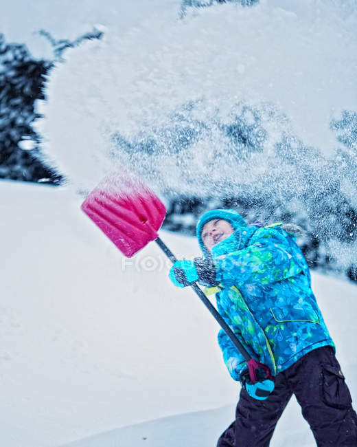 Ragazza spalando neve in cortile — Foto stock