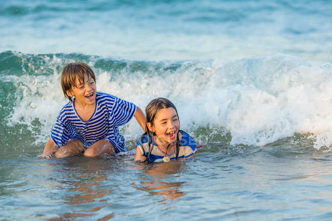 Niños jugando en el mar - foto de stock