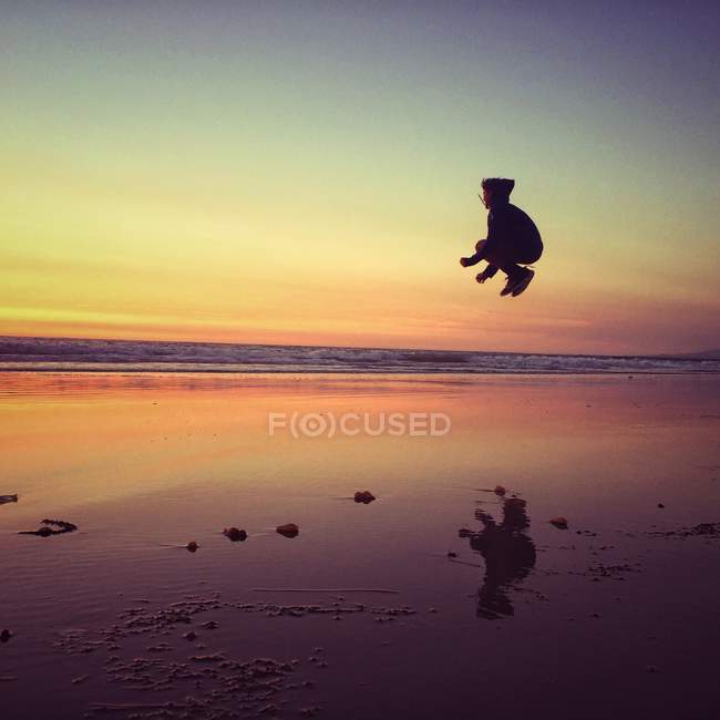 Boy jumping on beach — Stock Photo