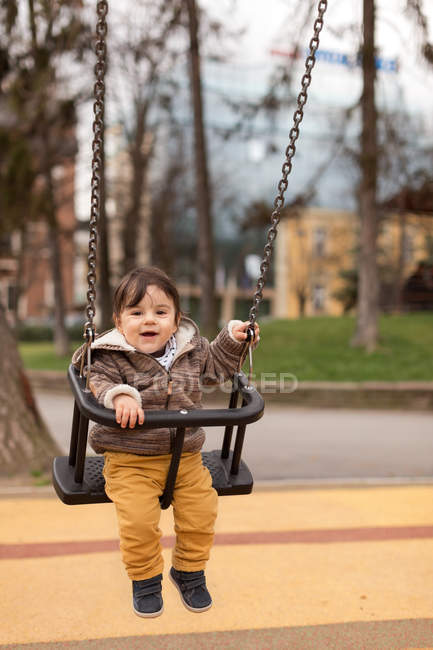 Хлопчик на гойдалках на дитячому майданчику — стокове фото