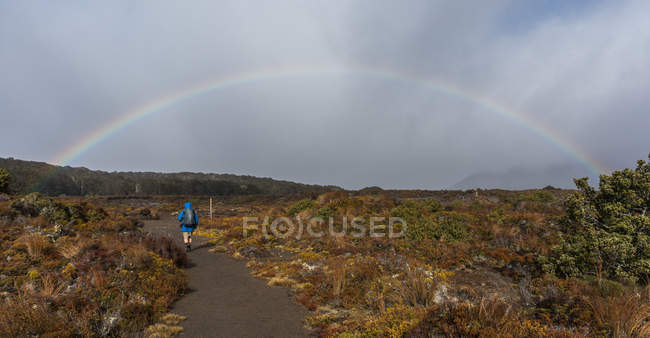 Uomo escursioni verso l'arcobaleno — Foto stock