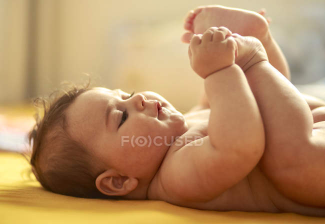 Baby boy playing with feet — Stock Photo