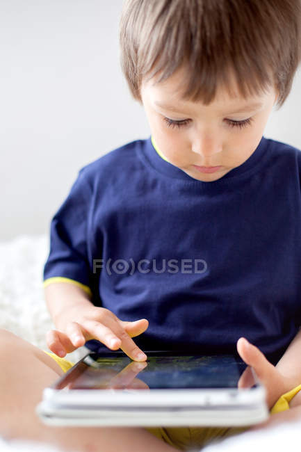 Niño jugando con la tableta digital - foto de stock