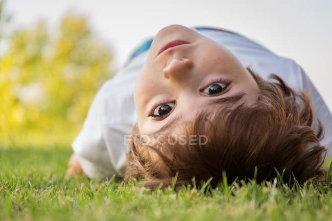 Junge liegt auf Rasen — Stockfoto