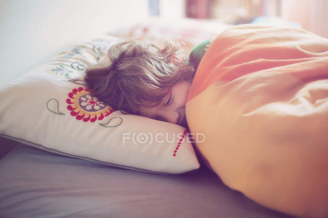 Мальчик спит в постели — стоковое фото
