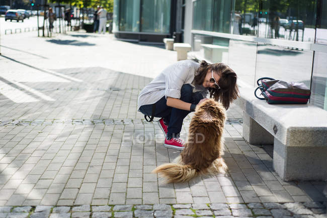 Young woman with dog outdoors — Stock Photo