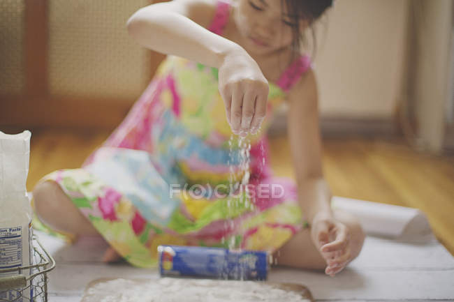 Ragazza seduta sul pavimento e cottura — Foto stock