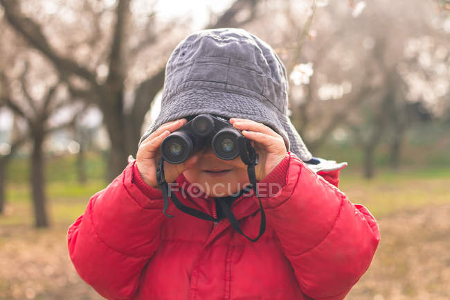Niño mirando en prismáticos de canal - foto de stock