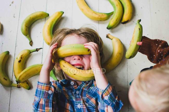 Mädchen mit Bananen bedeckt — Stockfoto
