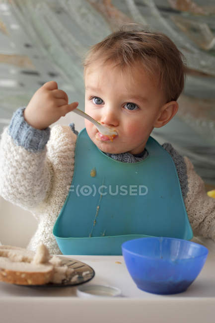 Baby boy eating at table — Stock Photo