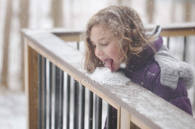 Девушка лижет снег — стоковое фото