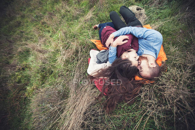 Couple couché sur l'herbe — Photo de stock