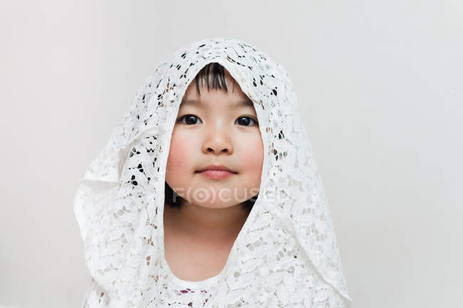 Girl in lace hood looking at camera — Stock Photo