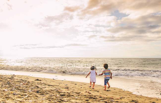 Giovane ragazzo e ragazza a piedi sulla spiaggia — Foto stock