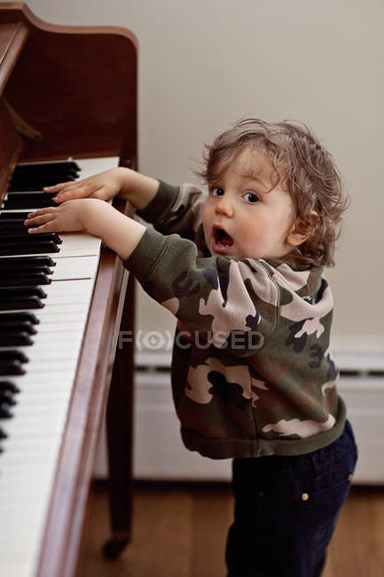 Baby boy singing and playing piano — Stock Photo