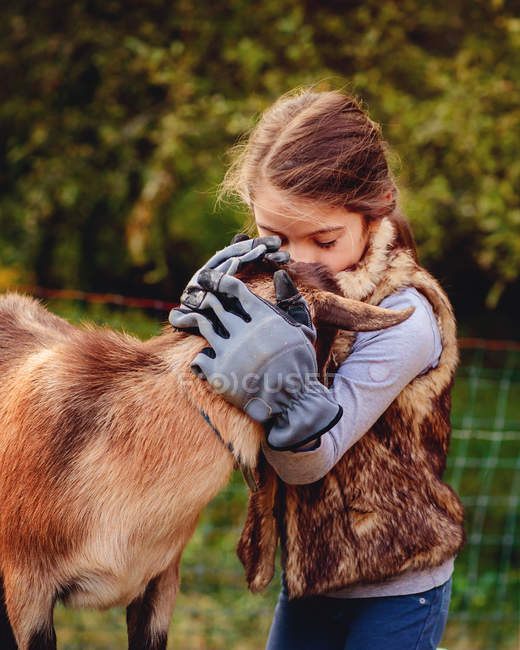 Girl kissing goat — Stock Photo