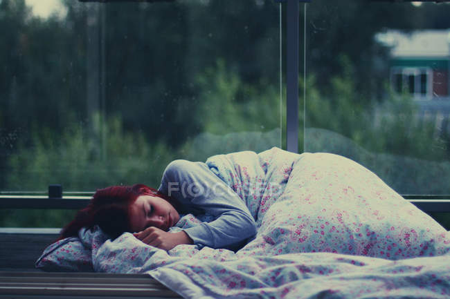 Young woman sleeping at bus shelter — Stock Photo