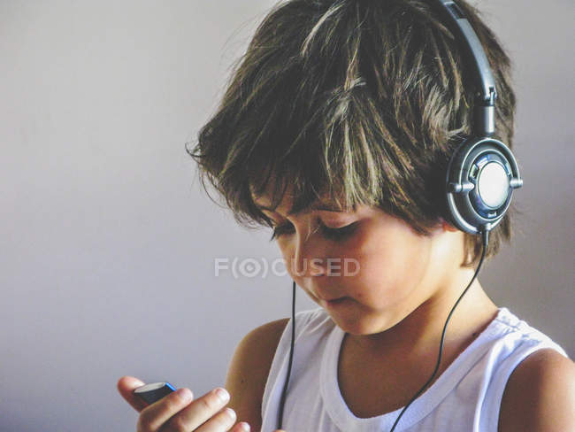Niño usando auriculares - foto de stock