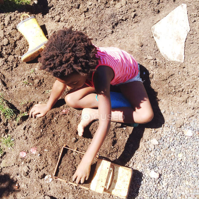 Маленькая девочка играет в грязи — стоковое фото