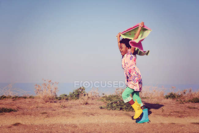 Mädchen läuft mit buntem Schal — Stockfoto