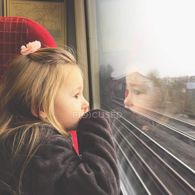 Girl looking through train window — Stock Photo