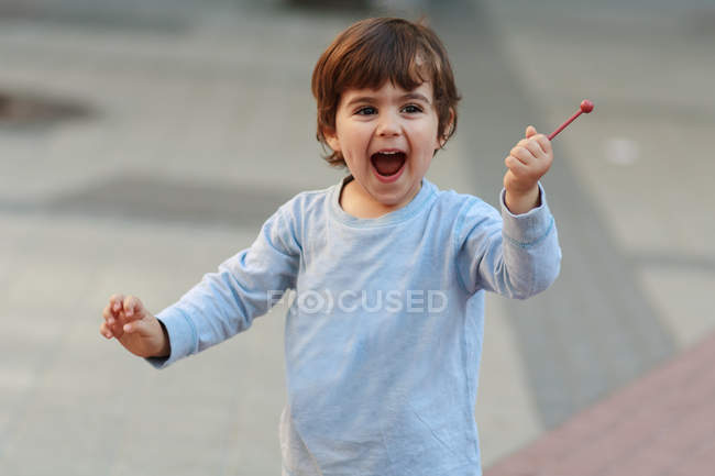 Мальчик держит конфеты на палочке — стоковое фото