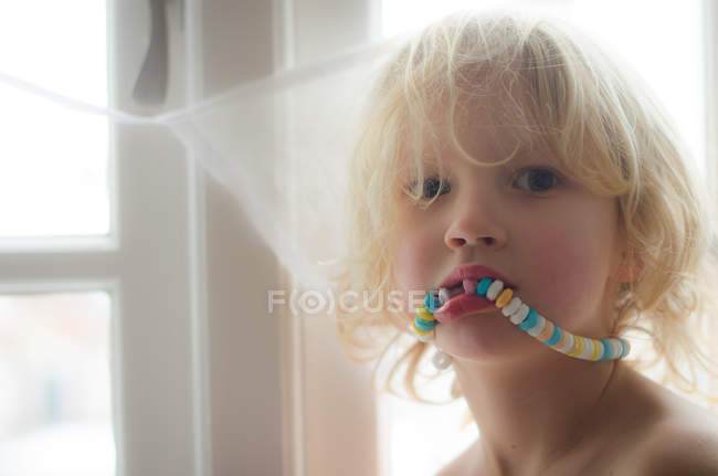 Garçon manger collier de bonbons — Photo de stock
